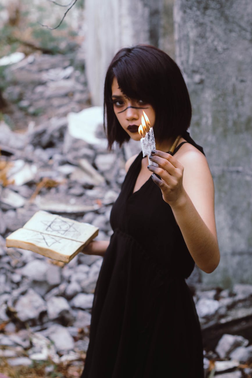 woman wears black sleeveless dress holding book