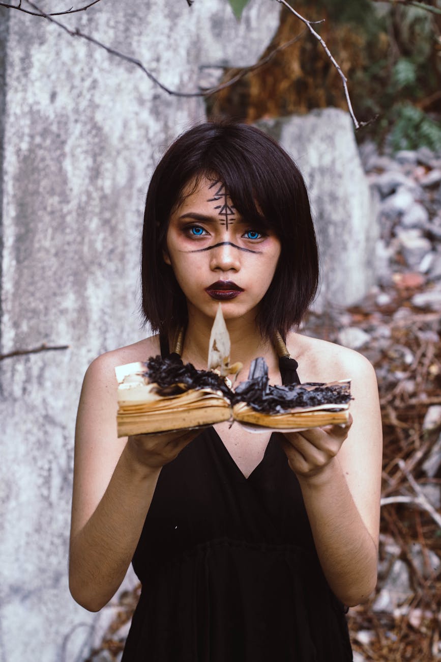 woman wearing black dress holding burnt book