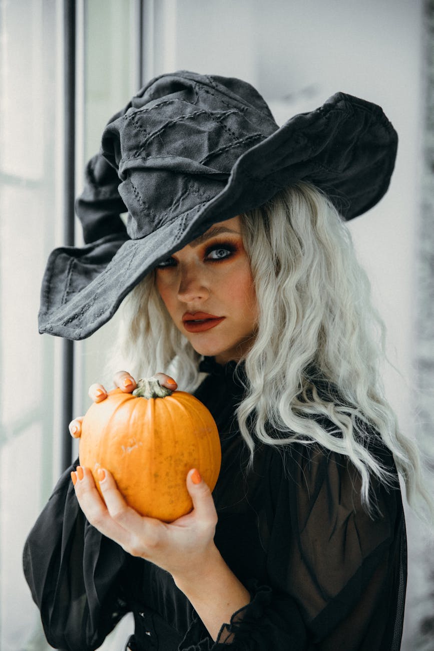 woman in halloween costume holding a pumpkin