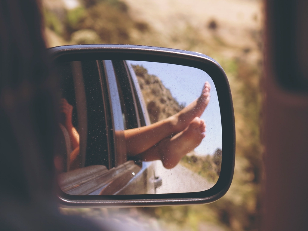 person sticking their feet car